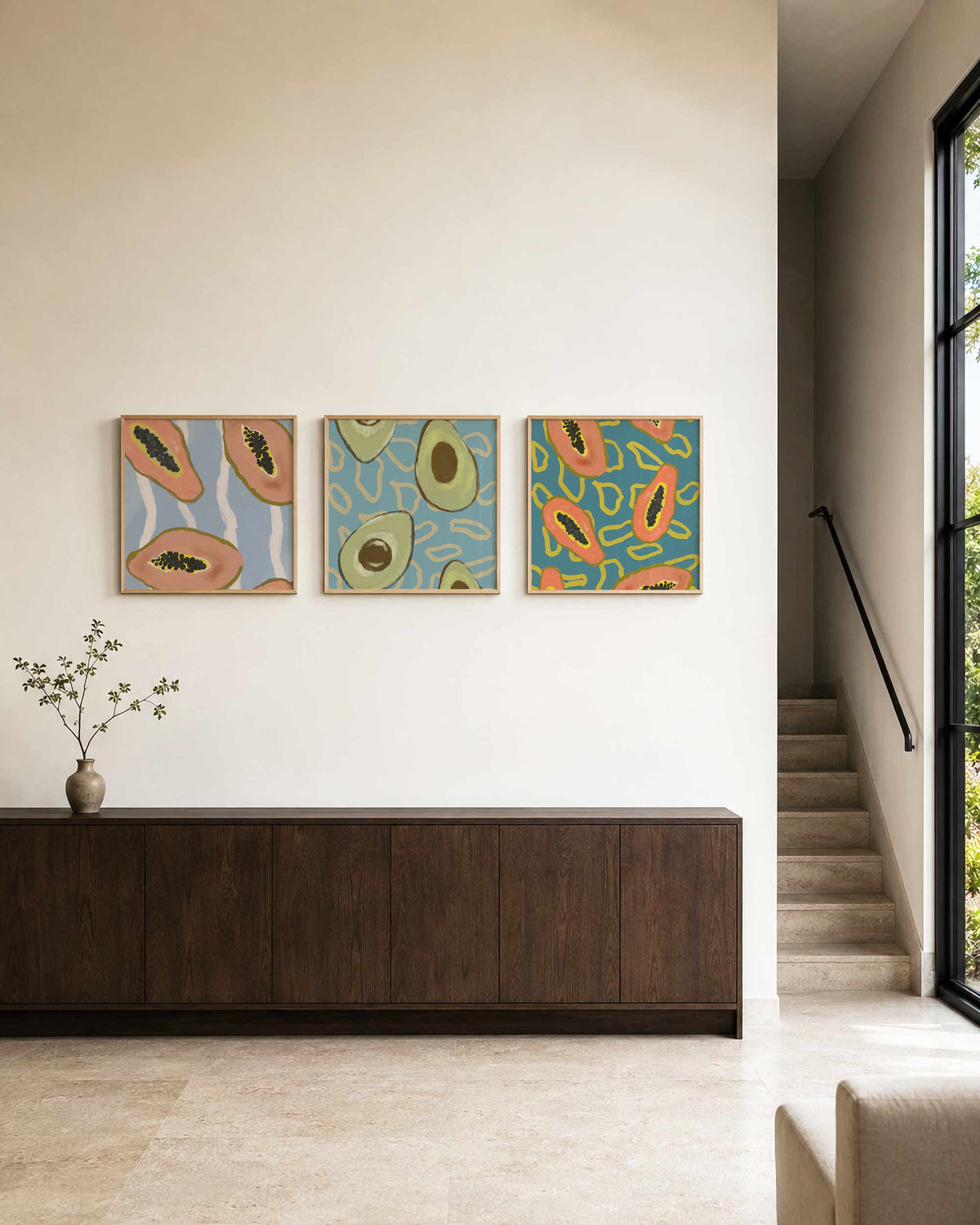 Interieurpresentatie van een driedelige vierkante posterset met papaja en avocado