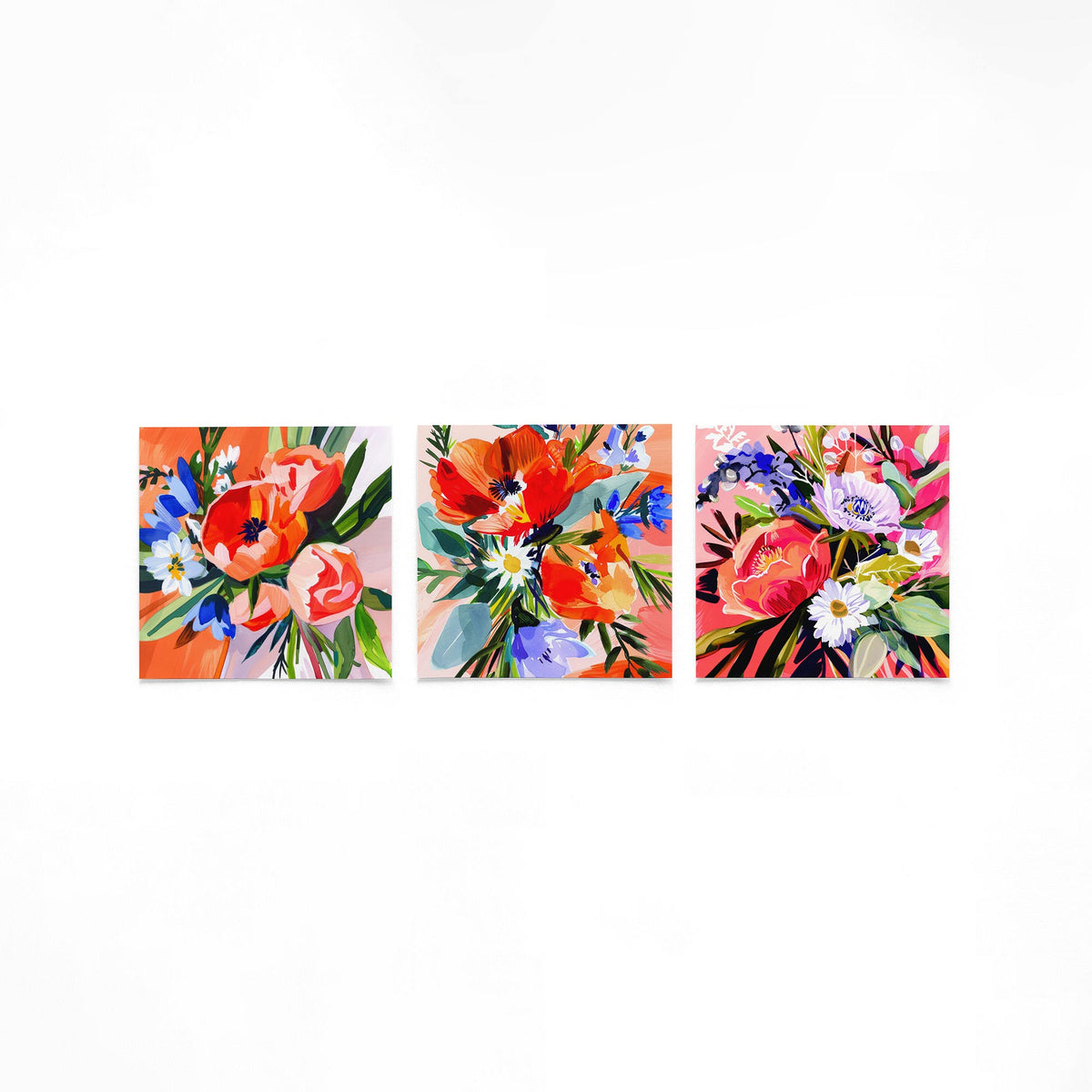 Drie vierkante posters met kleurrijke bloemen op een gebroken witte achtergrond