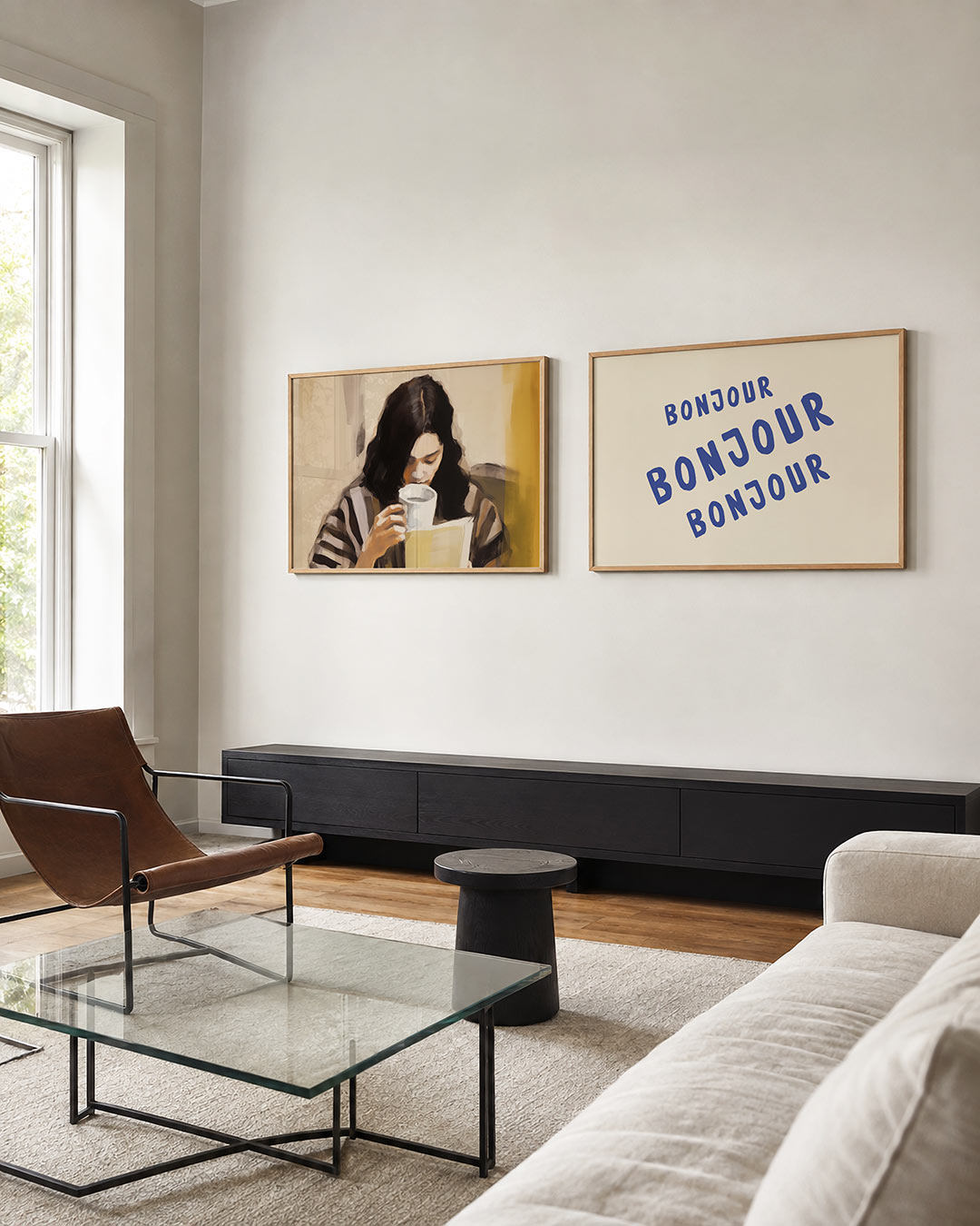 Interieurbeeld met twee liggende posters: een vrouw die een boek leest en een witte mok vasthoudt