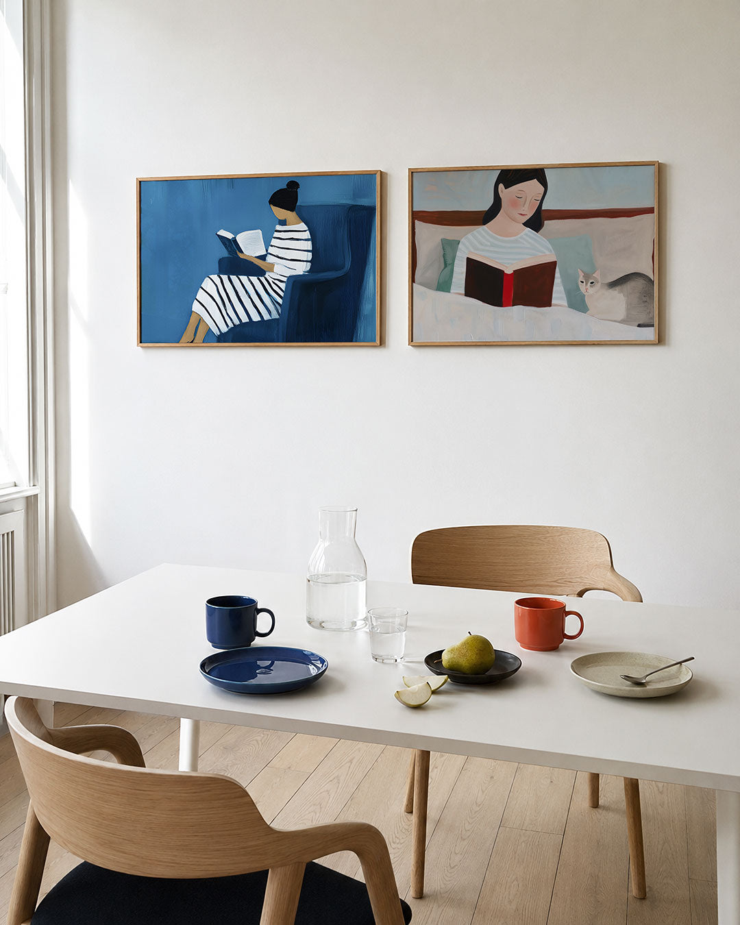 Tweedelige posterset met een vrouw in een gestreepte jurk met een boek op een blauwe stoel, getoond in een interieur
