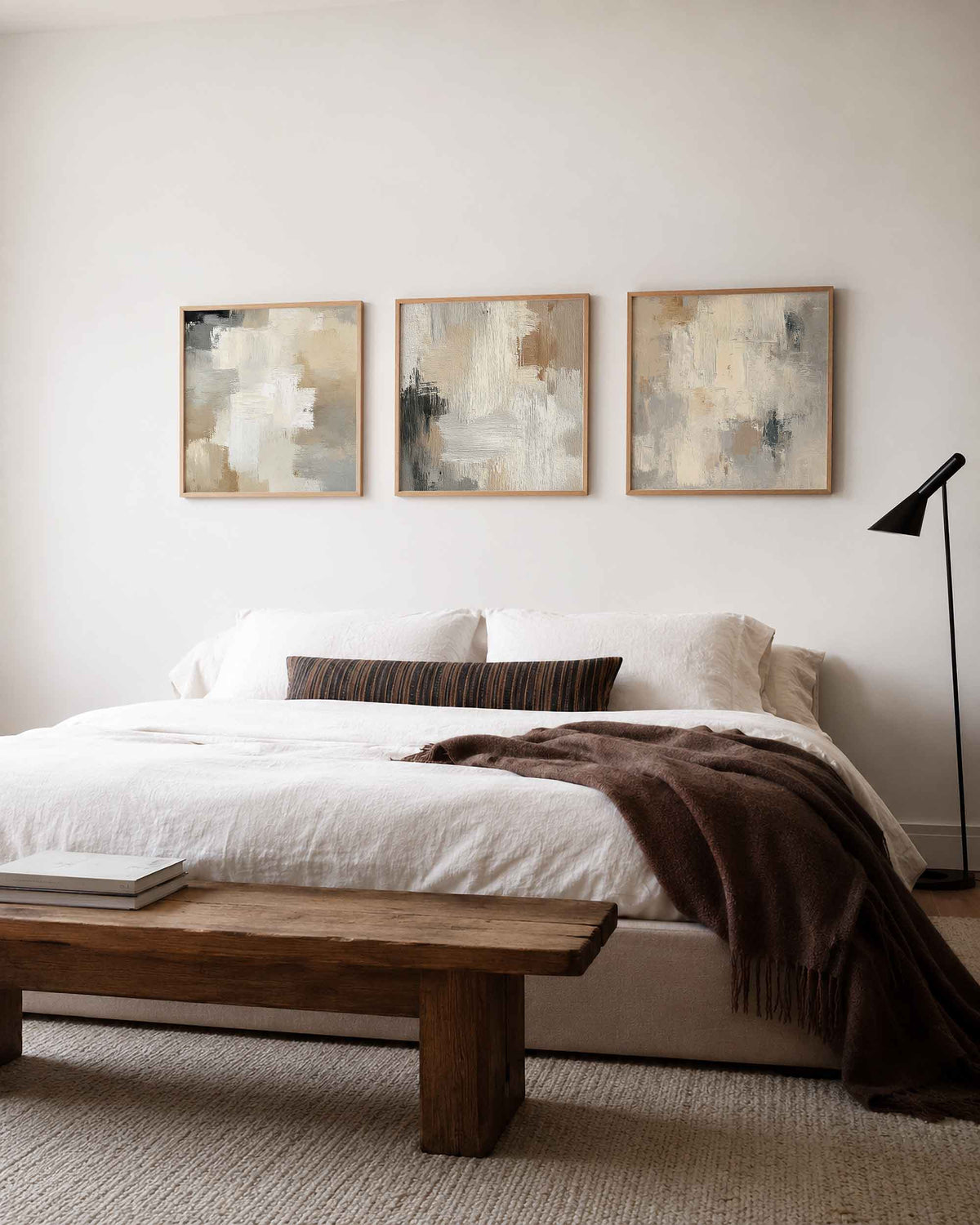 Interieurpresentatie van een driedelige vierkante posterset met abstracte beige schilderijen