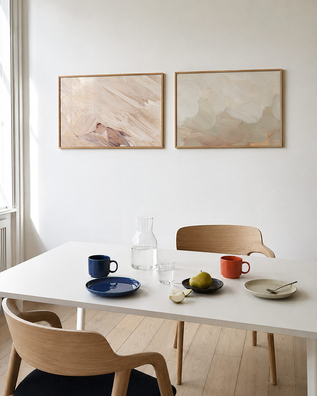 Interieurbeeld met twee liggende posters: vloeiende penseelstreken in zachte beige tinten