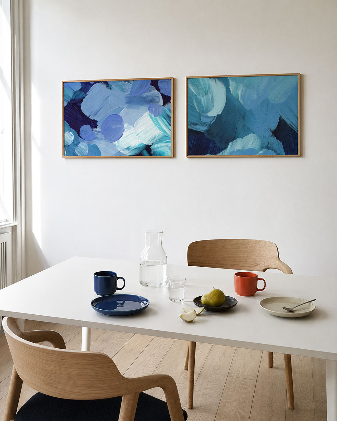 Interieurbeeld met twee liggende posters: deze tweedelige posterset heeft blauwe en turquoise penseelstreken