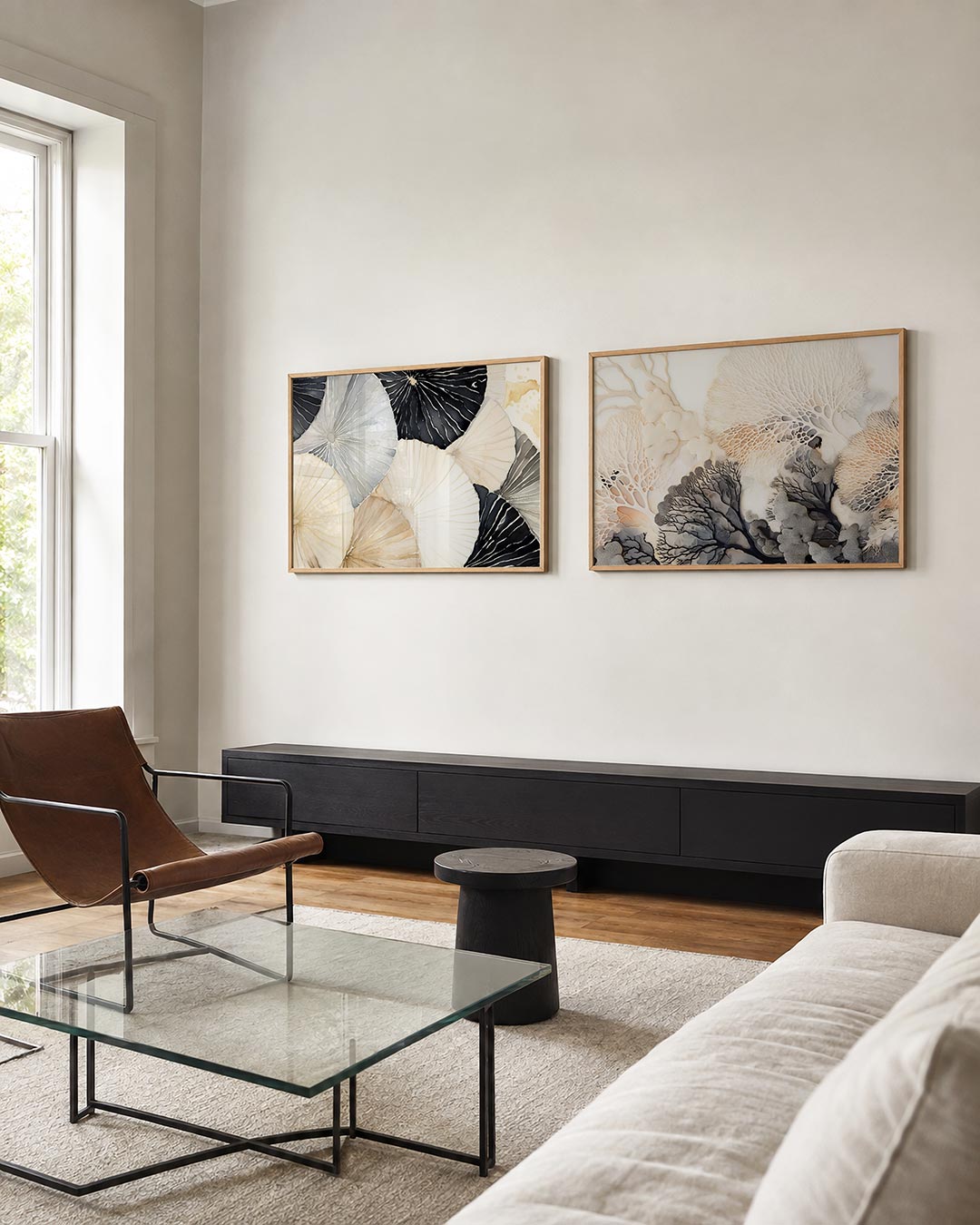 Tweedelige posterset met overlappende cirkelvormen in zachte tinten van zwart, grijs en beige, getoond in een interieur