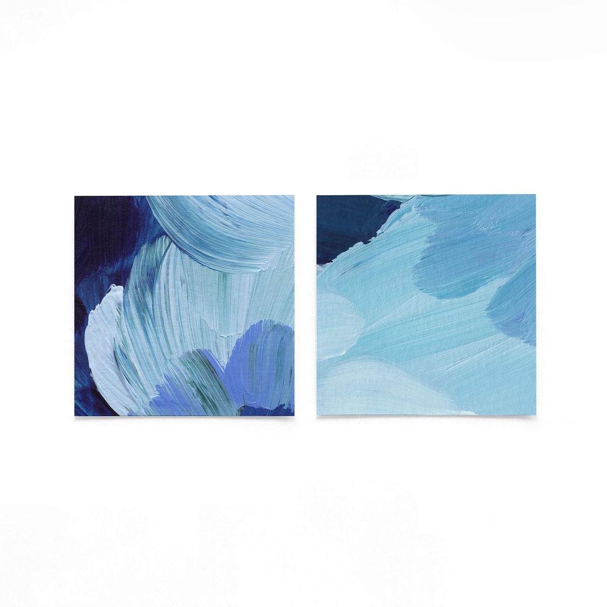 Twee vierkante posters met blauwe verfstreken op een gebroken witte achtergrond