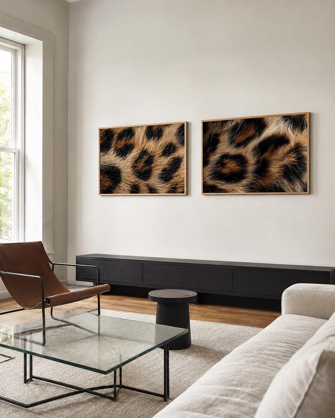 Twee liggende posters met een patroon van zwarte vlekken op een warme, goudbruine achtergrond, aan de muur in een interieur