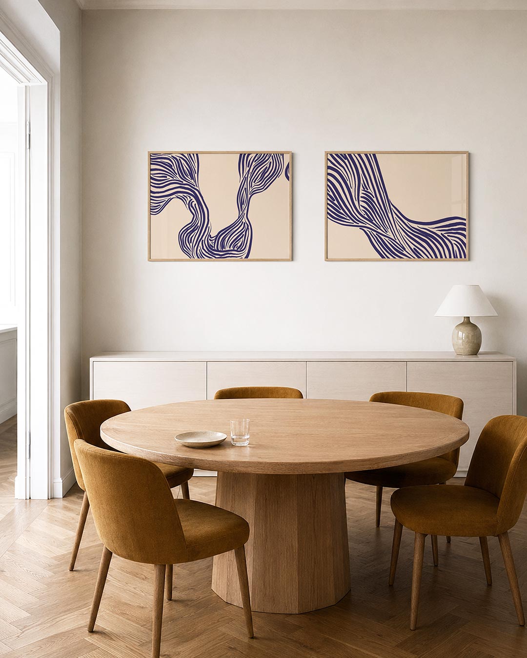 Twee liggende posters met vloeiende, golvende lijnen in diep paars op een zachte crèmekleurige, aan de muur in een interieur