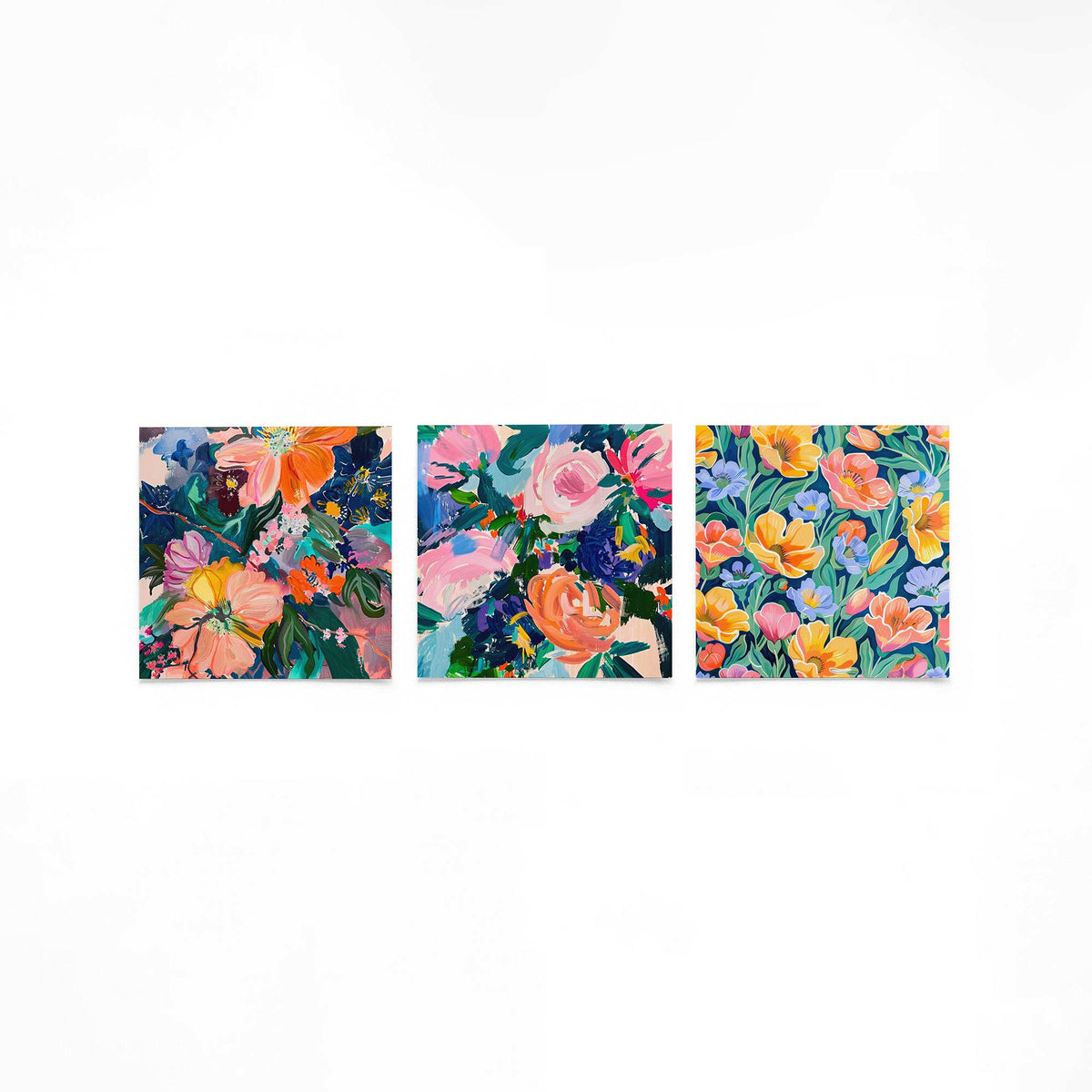 Drie vierkante posters met kleurrijke bloemen op een gebroken witte achtergrond