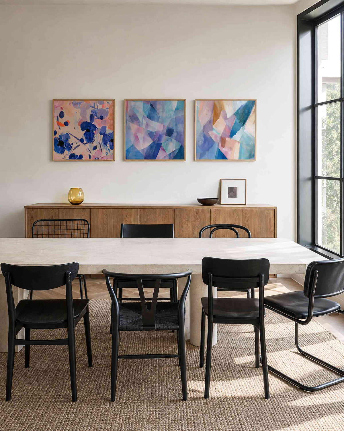 Interieurpresentatie van een driedelige vierkante posterset met abstracte kleurencompositie