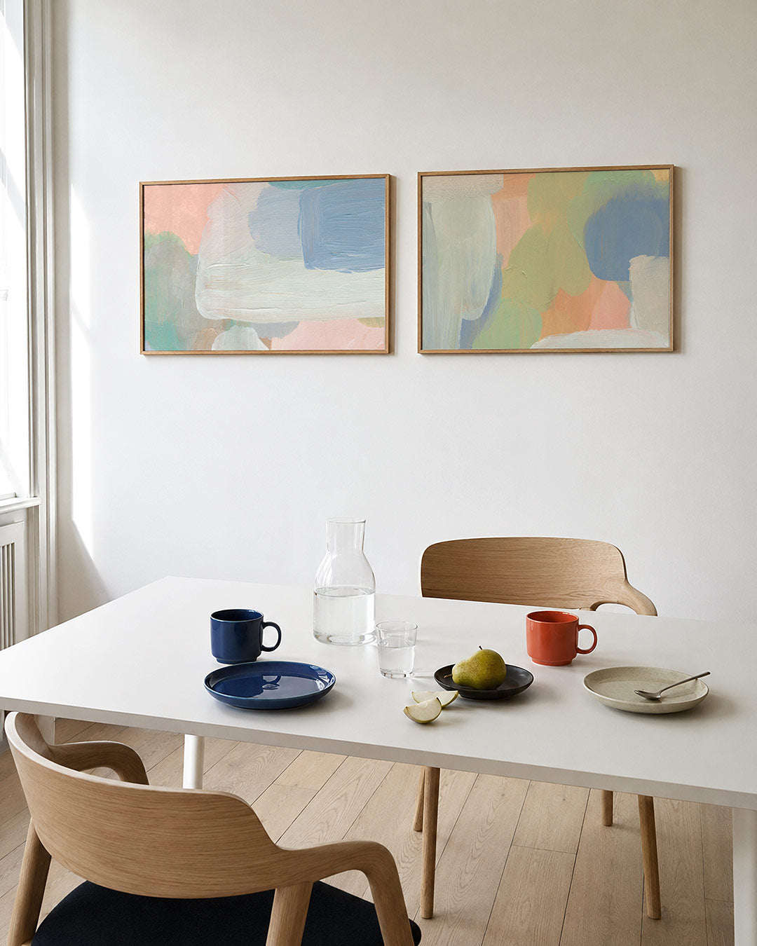Tweedelige posterset met vloeiende penseelstreken in pastelkleuren, getoond in een interieur