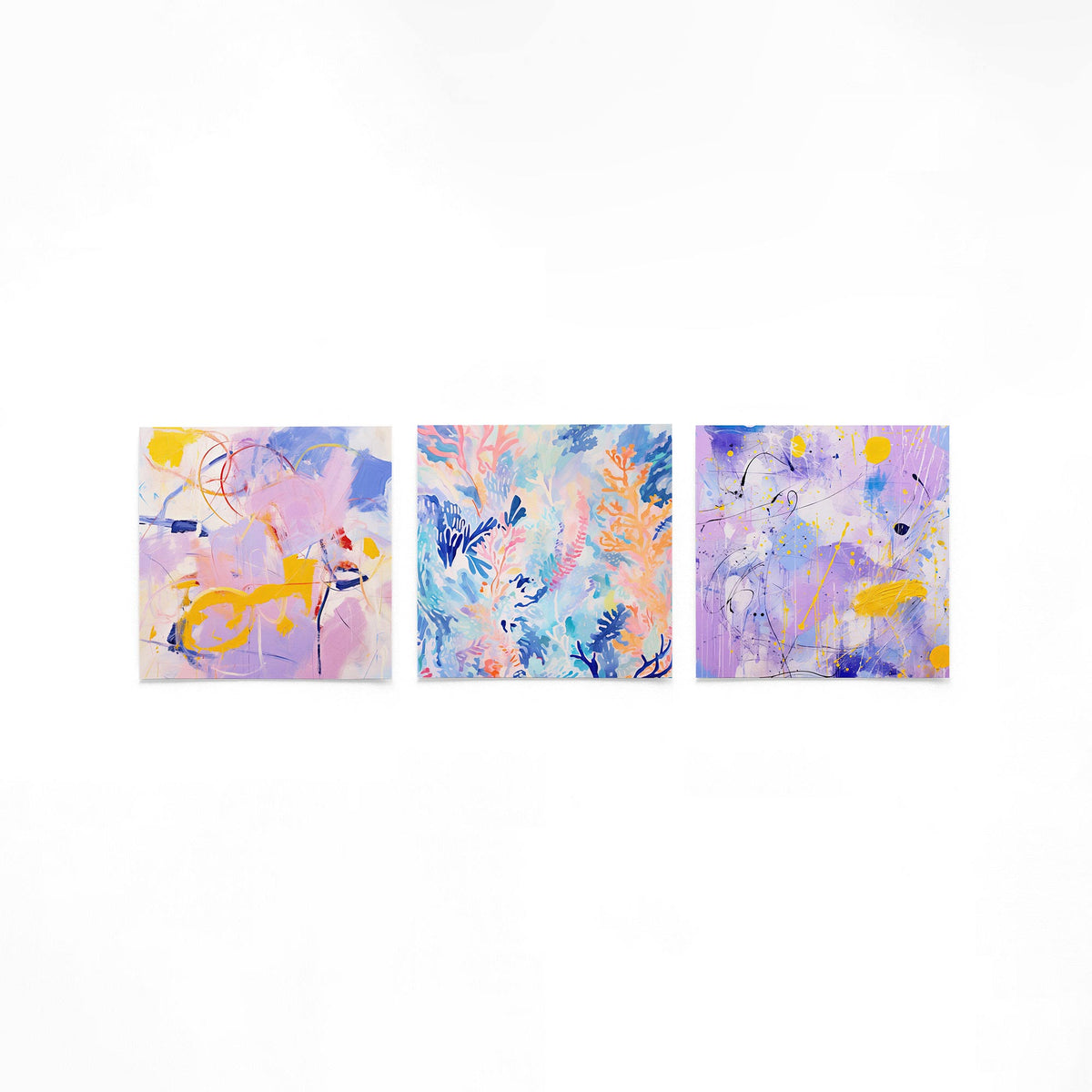 Drie vierkante posters met abstracte kleurexpressie op een gebroken witte achtergrond