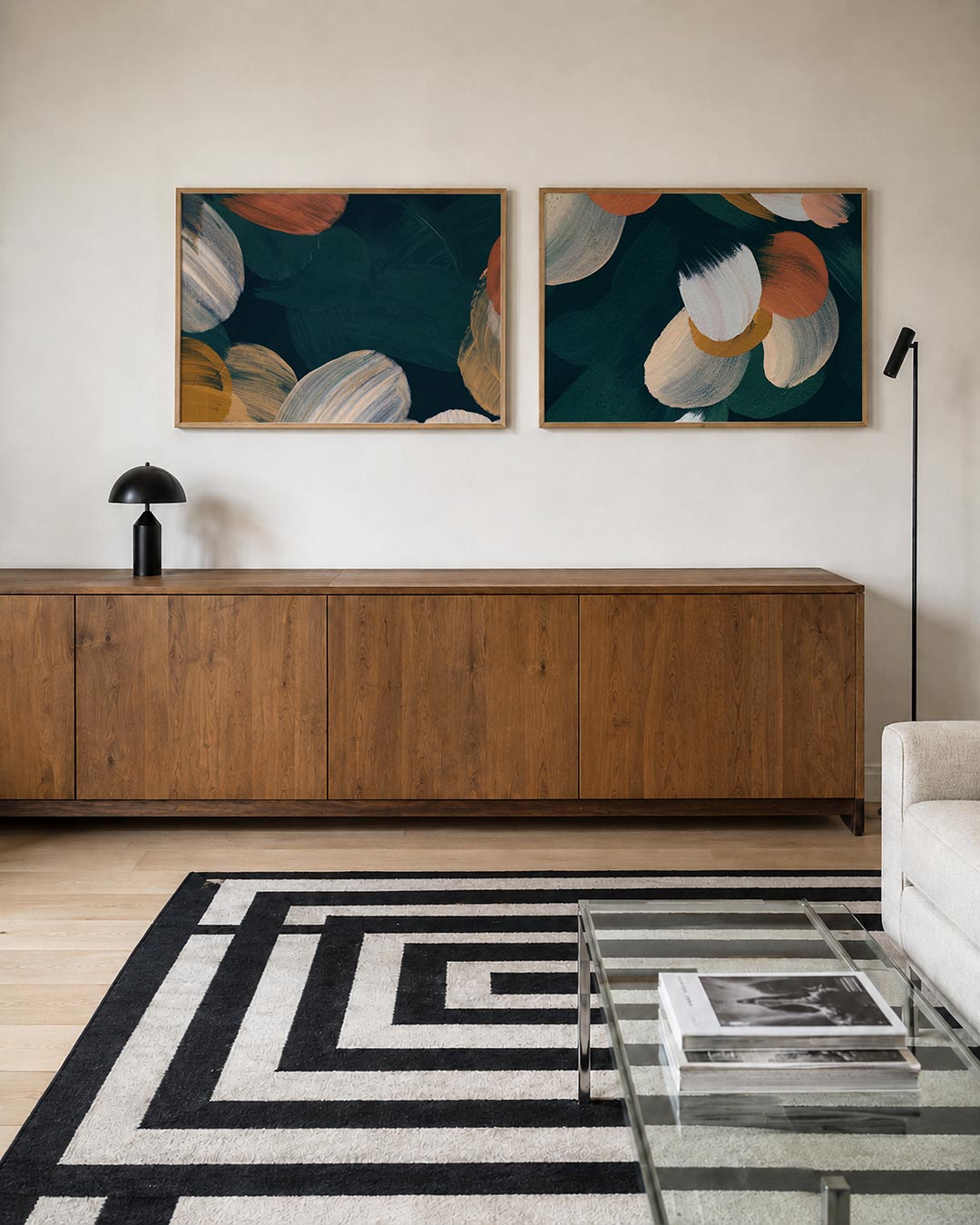 Twee liggende posters met vloeiende penseelstreken in warme tinten, aan de muur in een interieur