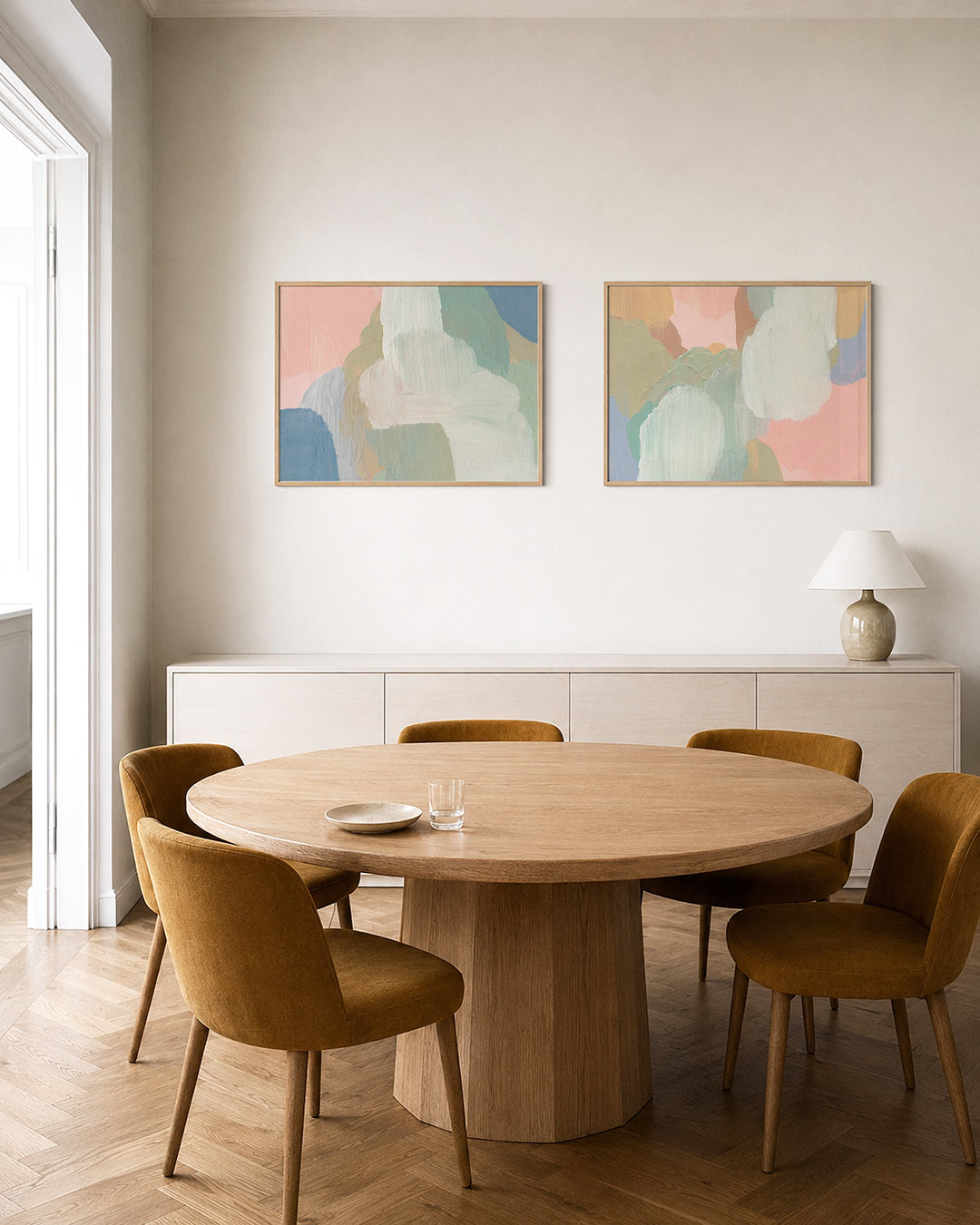 Twee liggende posters met vloeiende penseelstreken in pastelkleuren, aan de muur in een interieur
