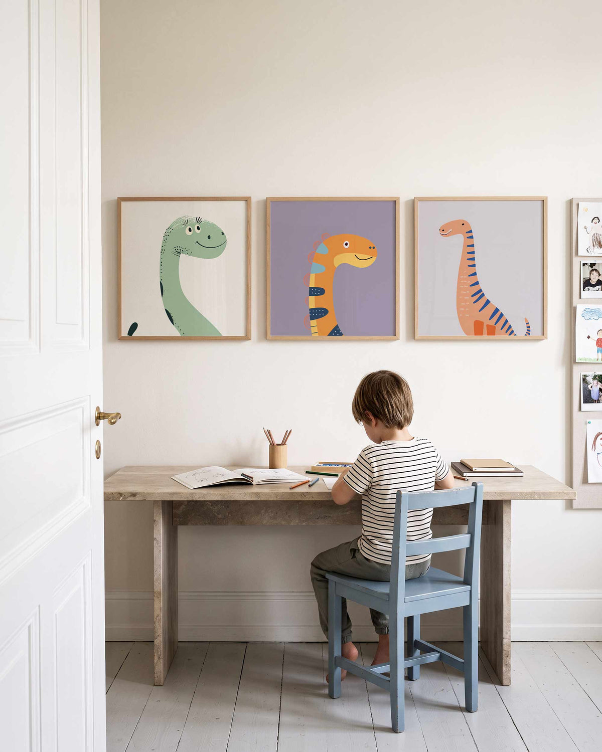 Interieurpresentatie van een driedelige vierkante posterset met vrolijke dinosaurus