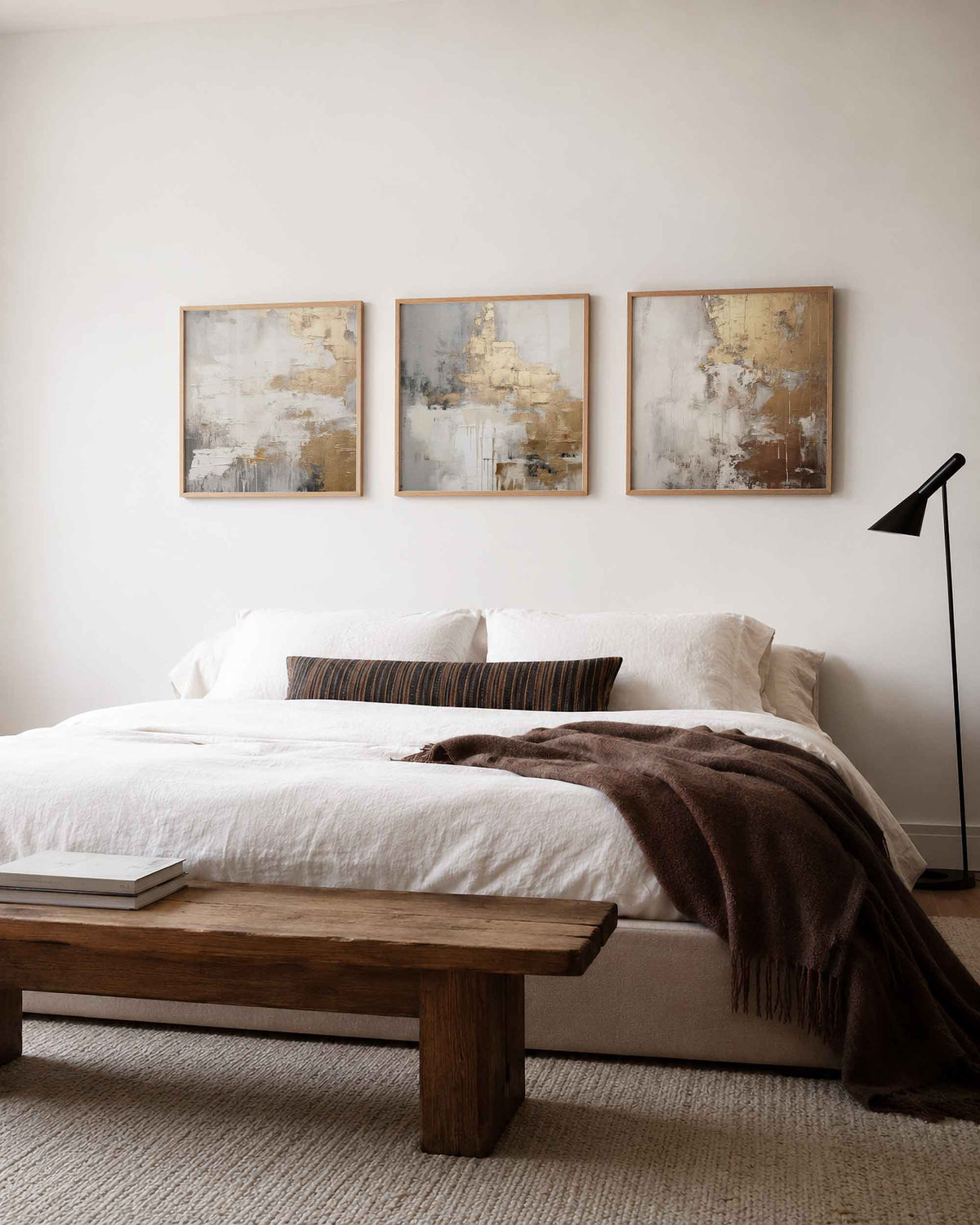 Interieurpresentatie van een driedelige vierkante posterset met aardetinten abstract