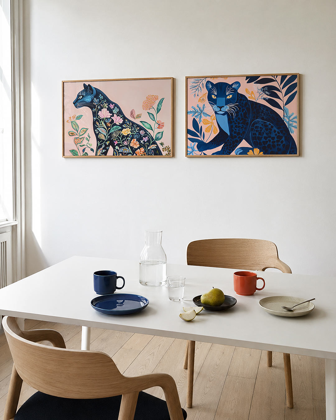 Twee liggende posters met een silhouet van een kat gevuld met kleurrijke bloemen en bladeren, aan de muur in een interieur
