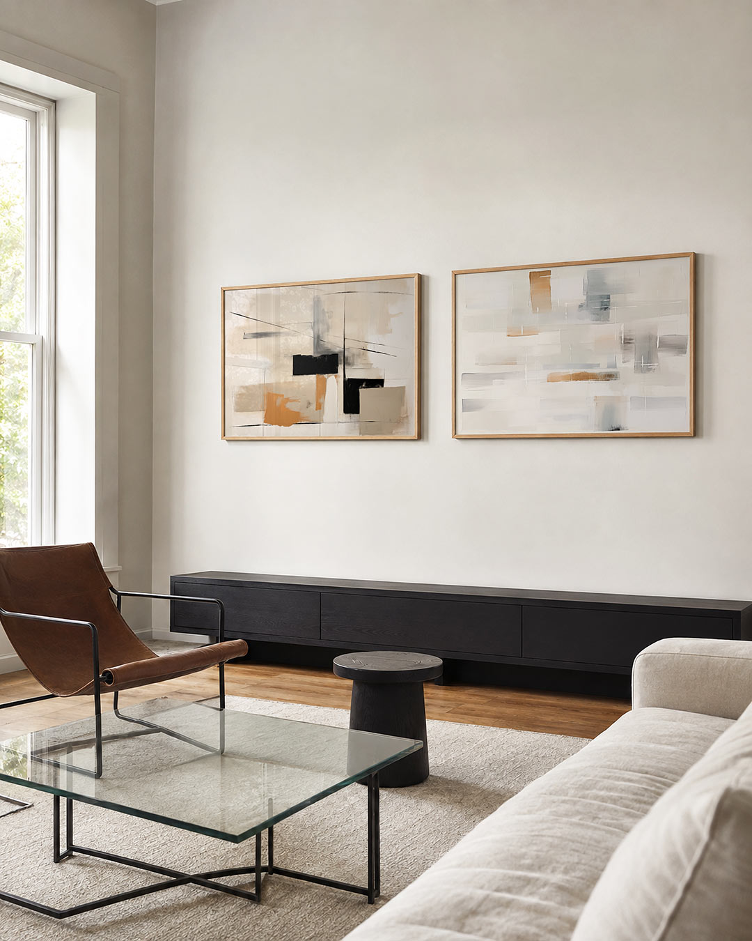 Tweedelige posterset met een spel van zwarte lijnen en kleurvlakken in beige, zwart en oranje, getoond in een interieur