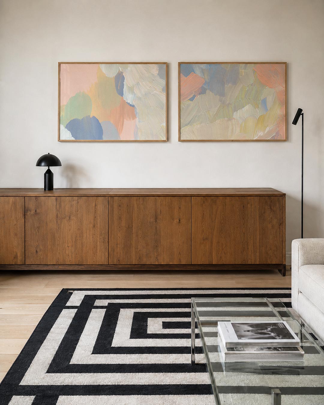 Twee liggende posters met zachte, pastelkleurige vlakken en vloeiende penseelstreken, aan de muur in een interieur