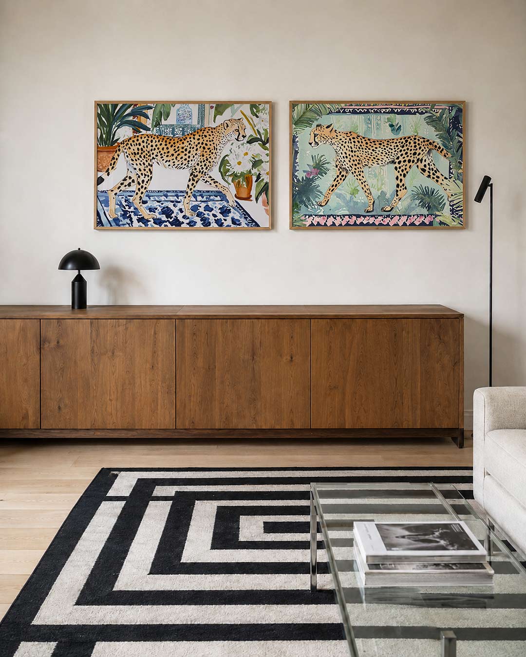 Twee liggende posters met een sierlijke cheetah loopt over een blauw-wit patroon, aan de muur in een interieur